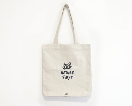 Borsa tote bianca naturale della collezione Nature First - Illustrazione originale con un design minimalista di un granchio di sabbia - Realizzata con certificazione Fair Trade e cotone biologico riciclato. Design ispirati alla natura per una moda sostenibile. Prodotta in Spagna.